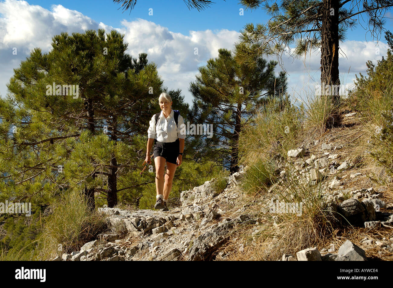 Healthy single woman 59 years old trekking hiking walking in mountains of Axarquia Andalucia Spain Post menopause building stron Stock Photo