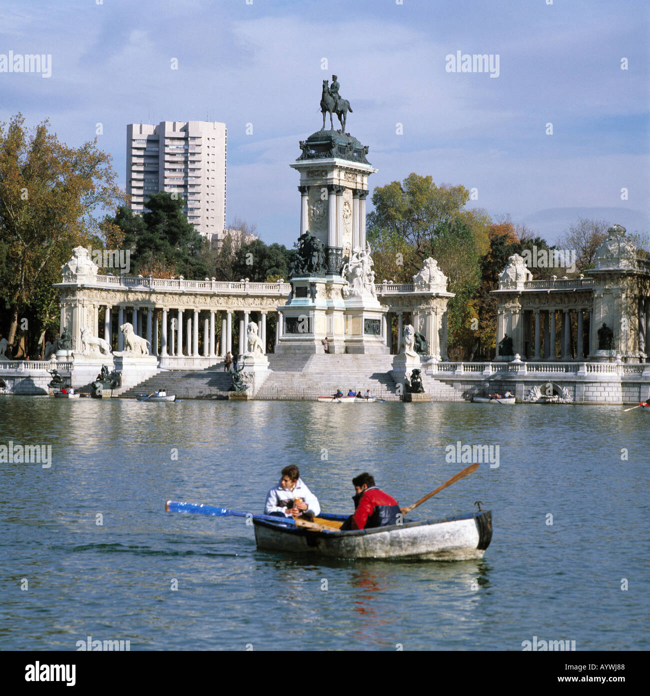 Parque del Retiro, Retiro-Park, Denkmal Koenig Alfons XII, Teich mit Ruderboot, zwei Jungen in einem Ruderboot, Hochhaus, herbstlich, Madrid Stock Photo
