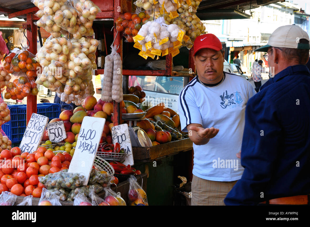 Man counting change for customer at a San Jose Costa Rica street side fruit stand Stock Photo