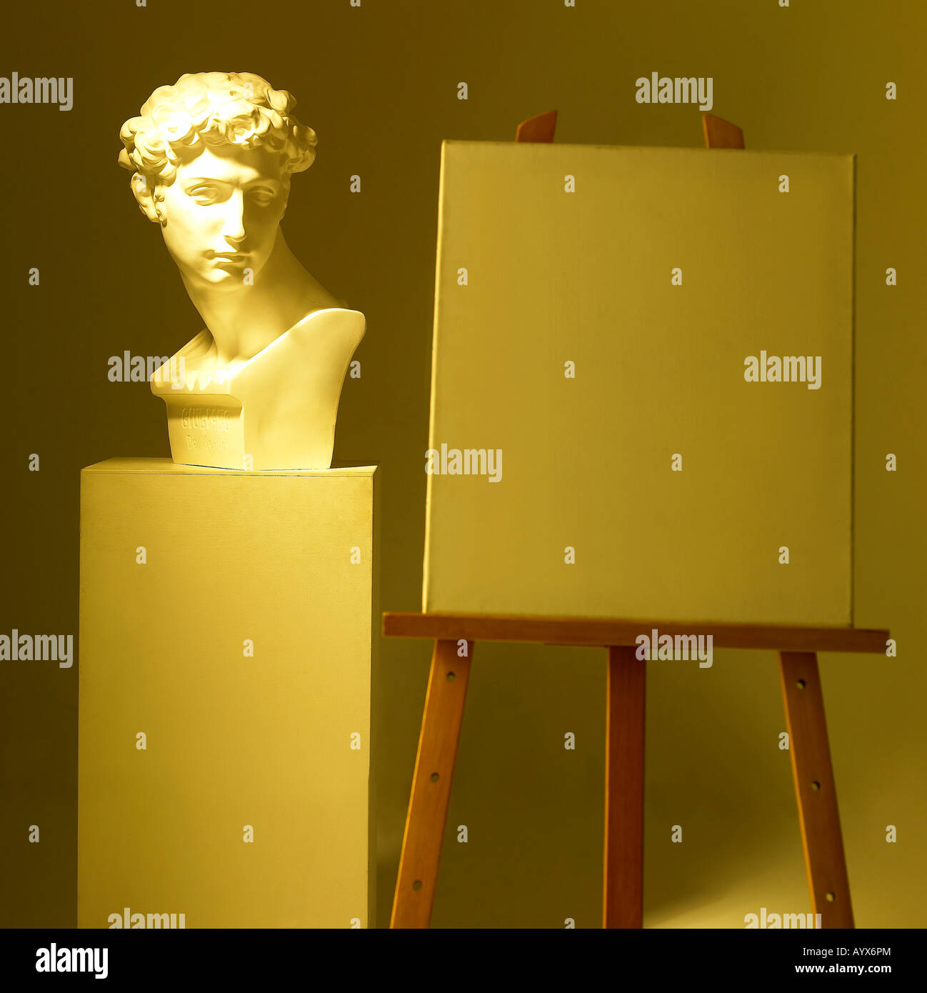 plaster bust and easel with yellow lighting Stock Photo