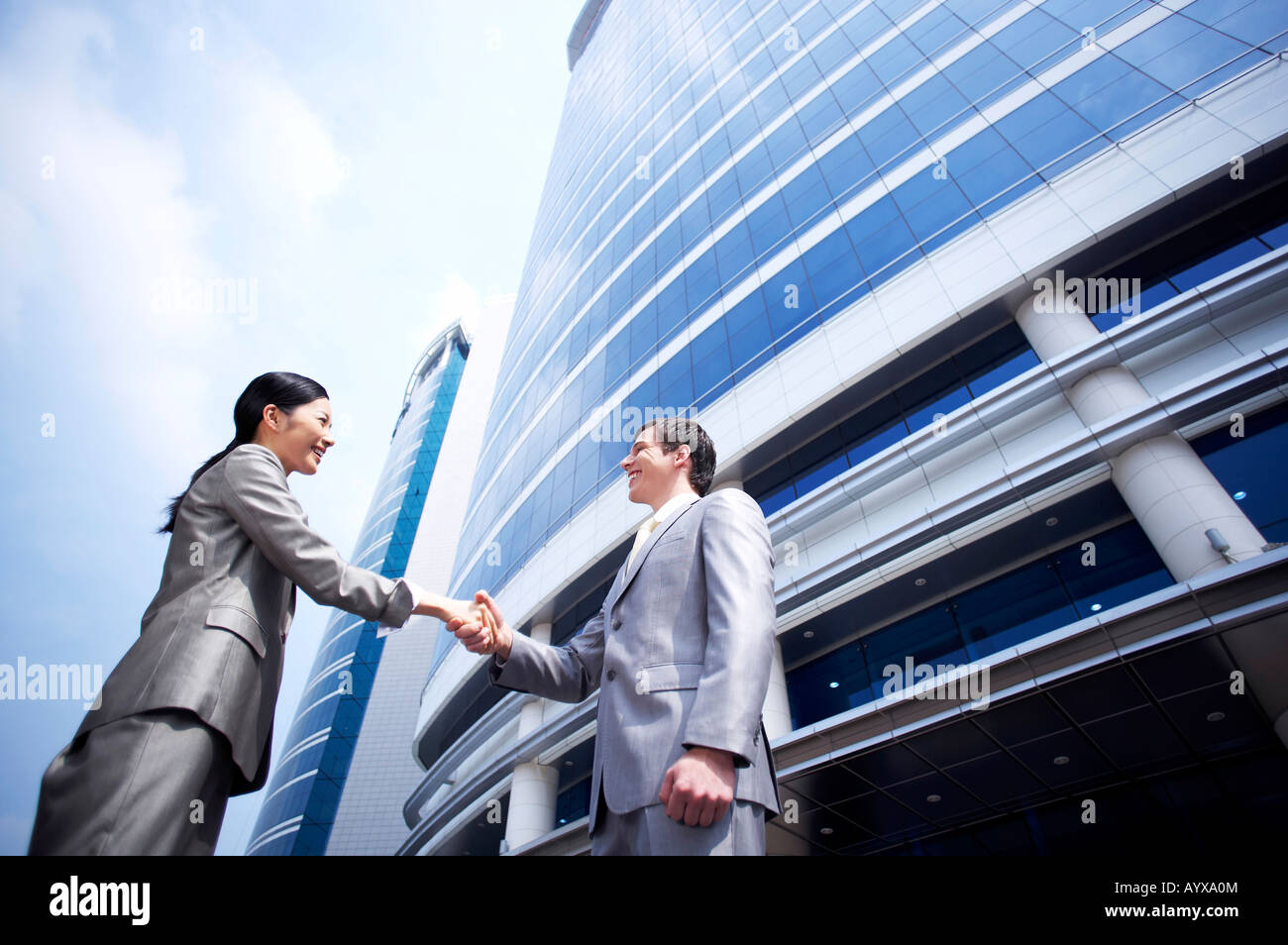man and woman shaking hands in front of building Stock Photo - Alamy