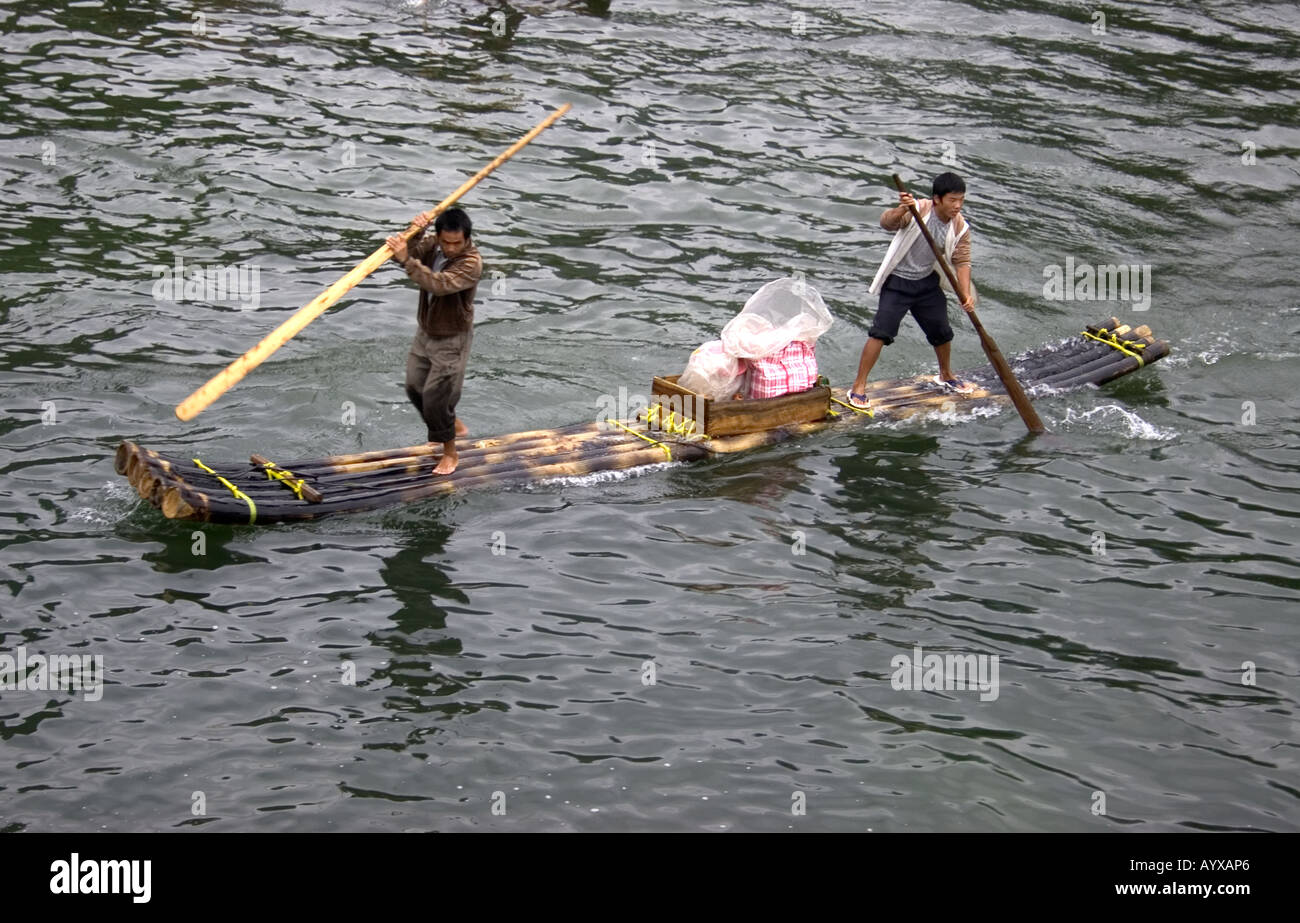 Two chinese fishermen pole their bamboo raft on the Li River. Guilin ...