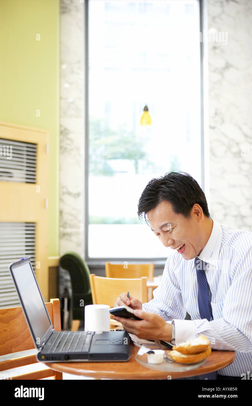 a being smile man taking a note with seeing laptop computer Stock Photo