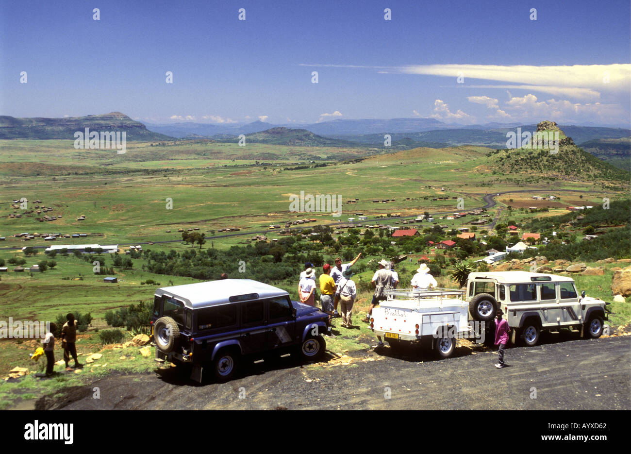 Parked Land Rovers and a family of visitors looking down on Isandlwana battlefield Natal South Africa Stock Photo