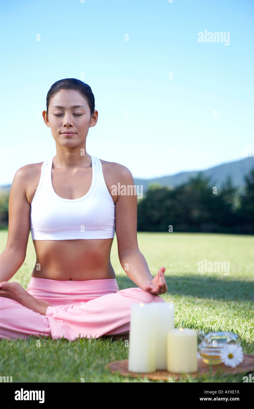 a woman sittin on grass field with motioning yoga Stock Photo - Alamy