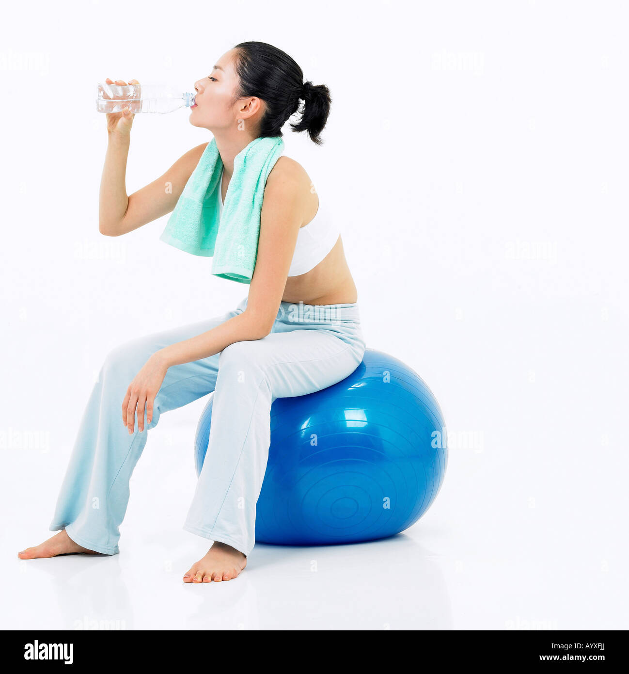 a woman drinking water with sitting on blue ball Stock Photo Alamy