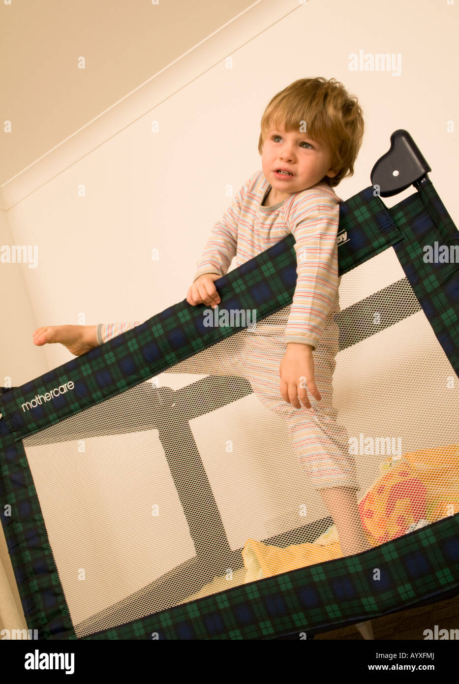 two year old boy climbing out of cot, escaping travel cot, bed, pen