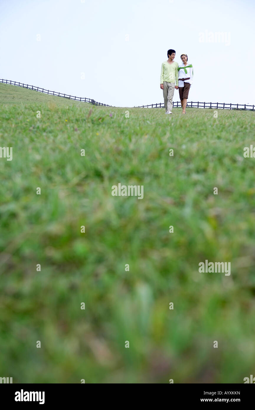 a couple walking in the grass field Stock Photo - Alamy