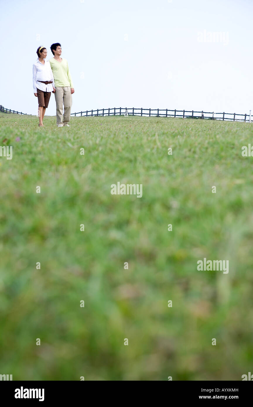 a couple walking in the grass field Stock Photo - Alamy