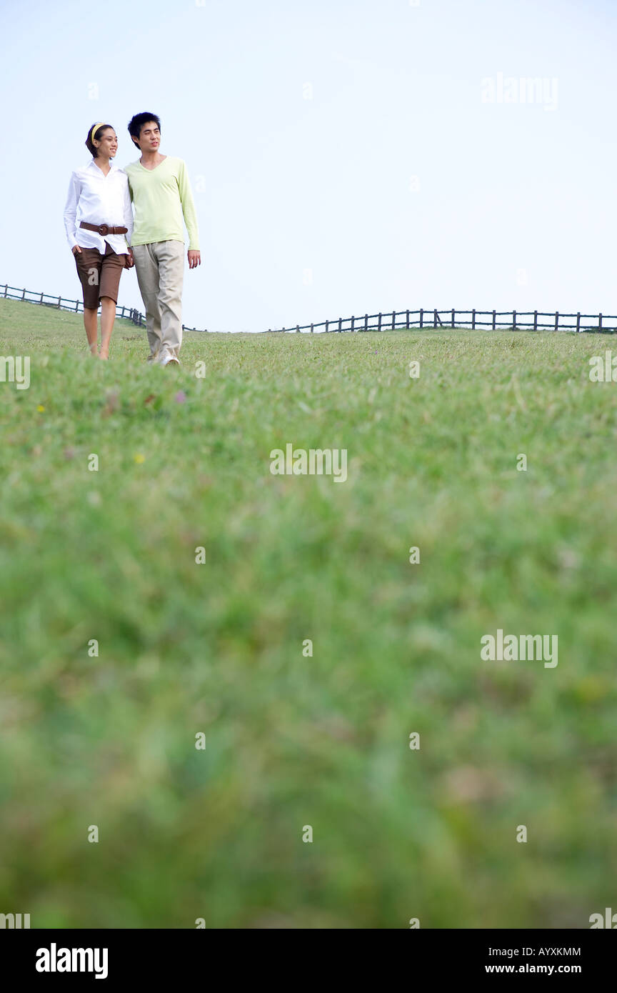 a couple walking in the grass field Stock Photo - Alamy