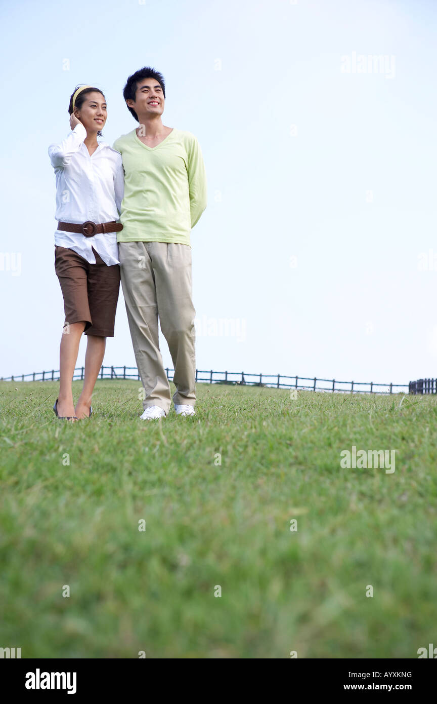 a couple walking in the grass field Stock Photo - Alamy