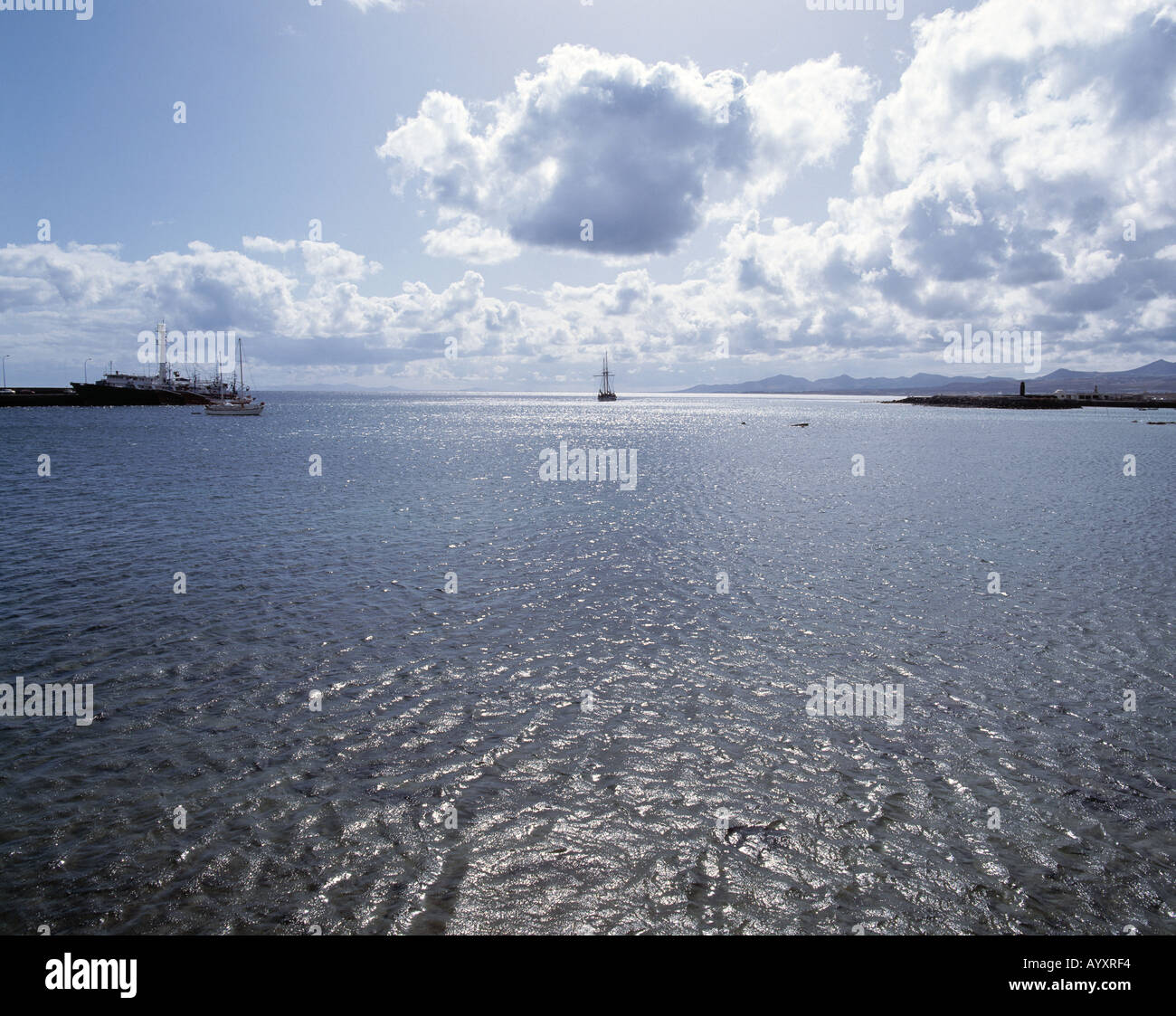 Kuestenlandschaft, Blick von der See zur Kueste, Hafeneinfahrt, Gegenlicht, Lichtreflexe auf dem Wasser, Arrecife, Lanzarote, Kanarische Inseln Stock Photo