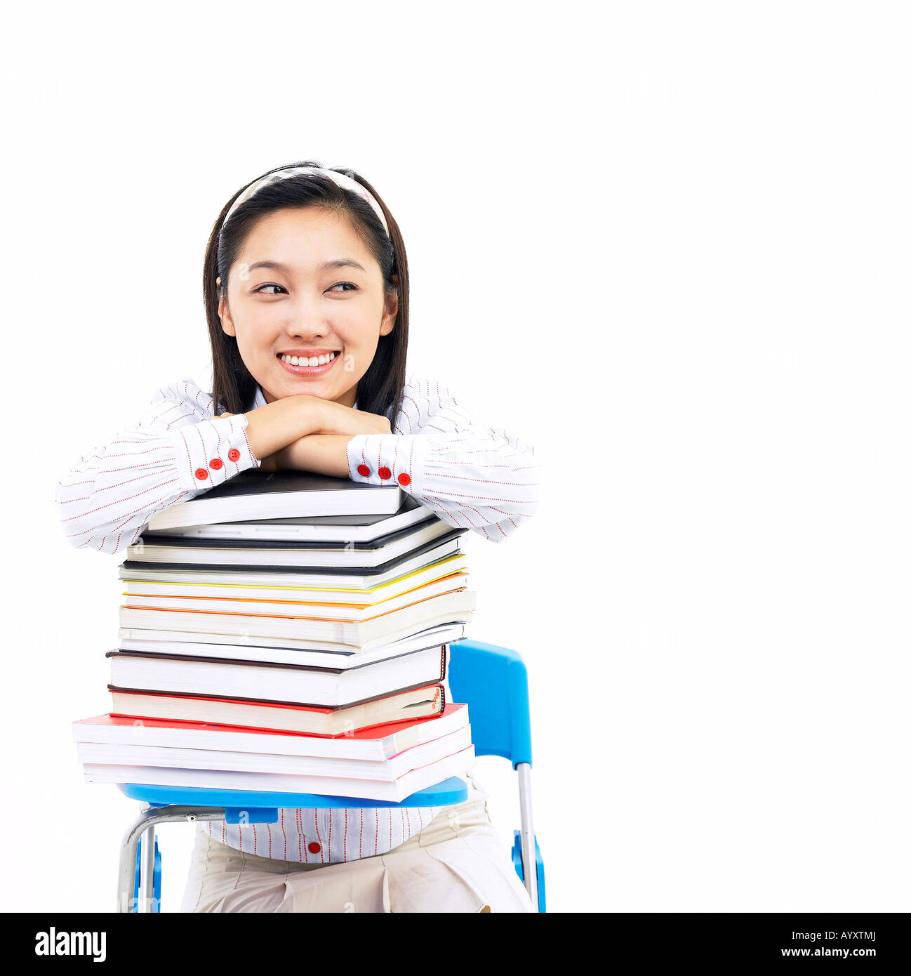 a girl student smiling in stacking books on the desk Stock Photo - Alamy