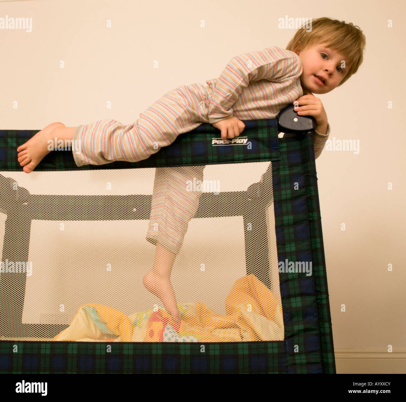 two year old boy climbing out of cot, escaping travel cot, bed, pen