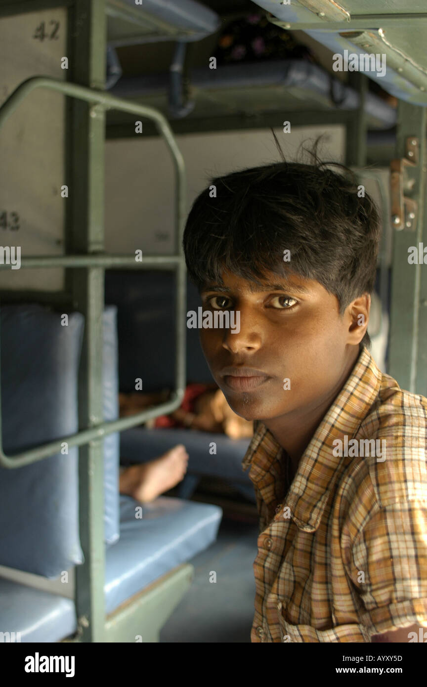 A young indian man looking at camera inside 3 tir no AC car of Indian Railways India Asia Stock Photo
