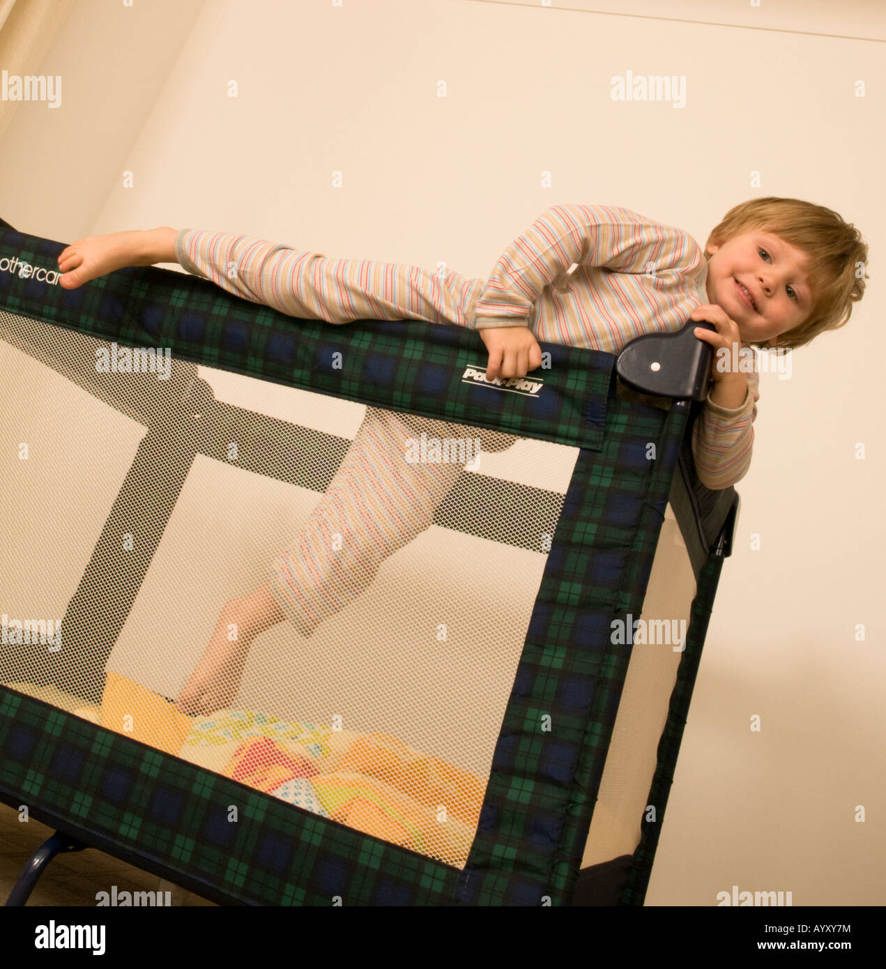 two year old boy climbing out of cot, travel cot, bed, pen Stock Photo Alamy