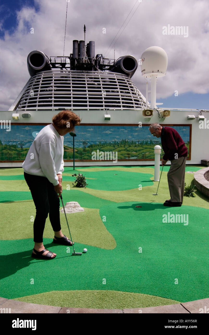 An elderly couple play crazy golf on a cruise ship. Stock Photo