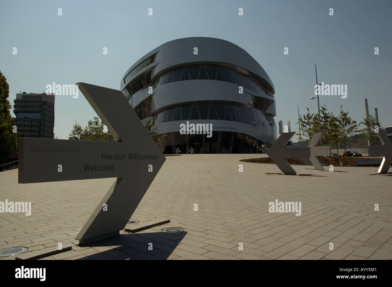 Mercedes Museum stuttgart with entrance arrows in foreground and factory in the background Stock Photo