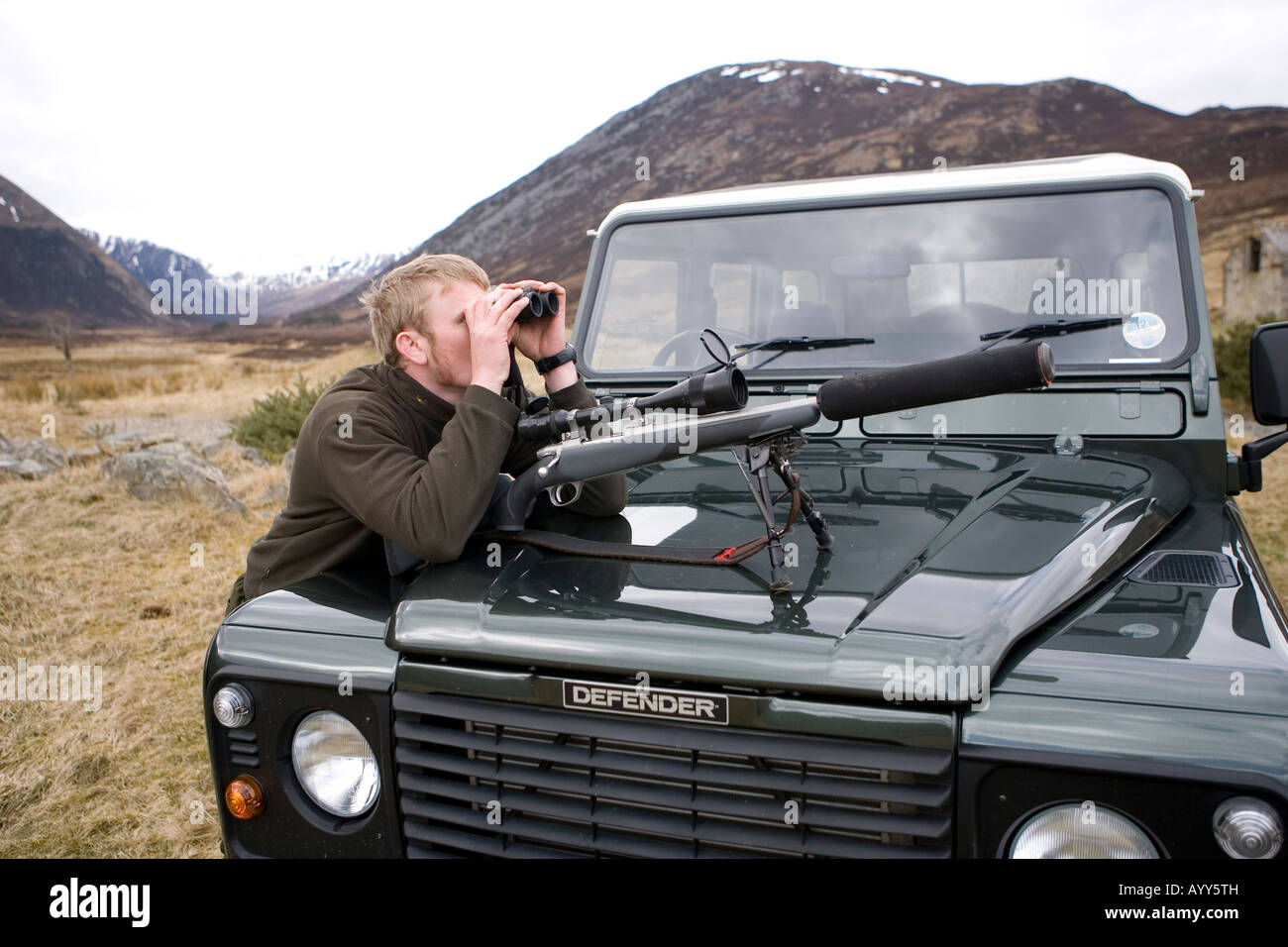 Alladale stalker David Clark watching red deer beside Land Rover, Alladale Estate, Scotland Stock Photo