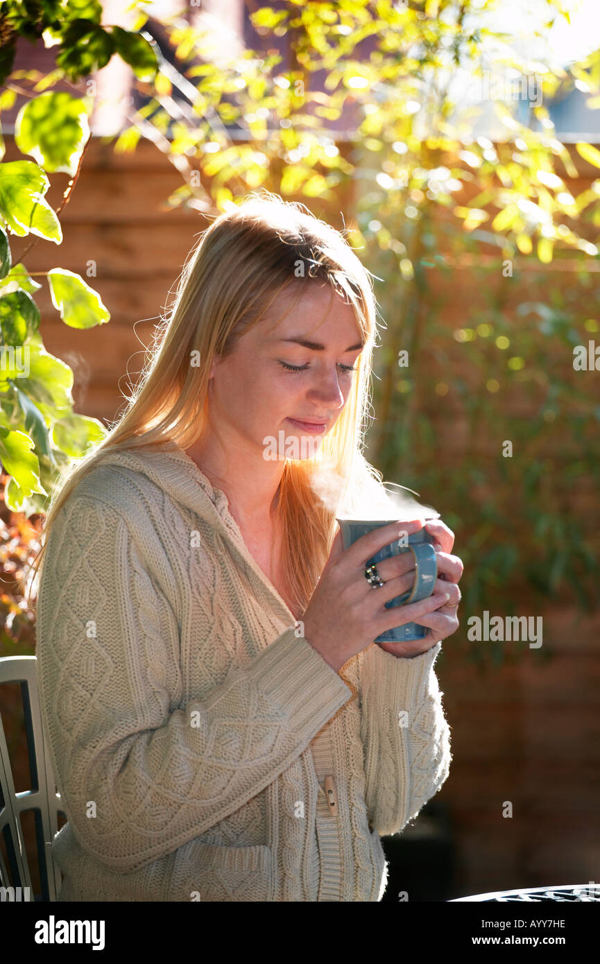 young woman relaxing with a hot drink Stock Photo - Alamy