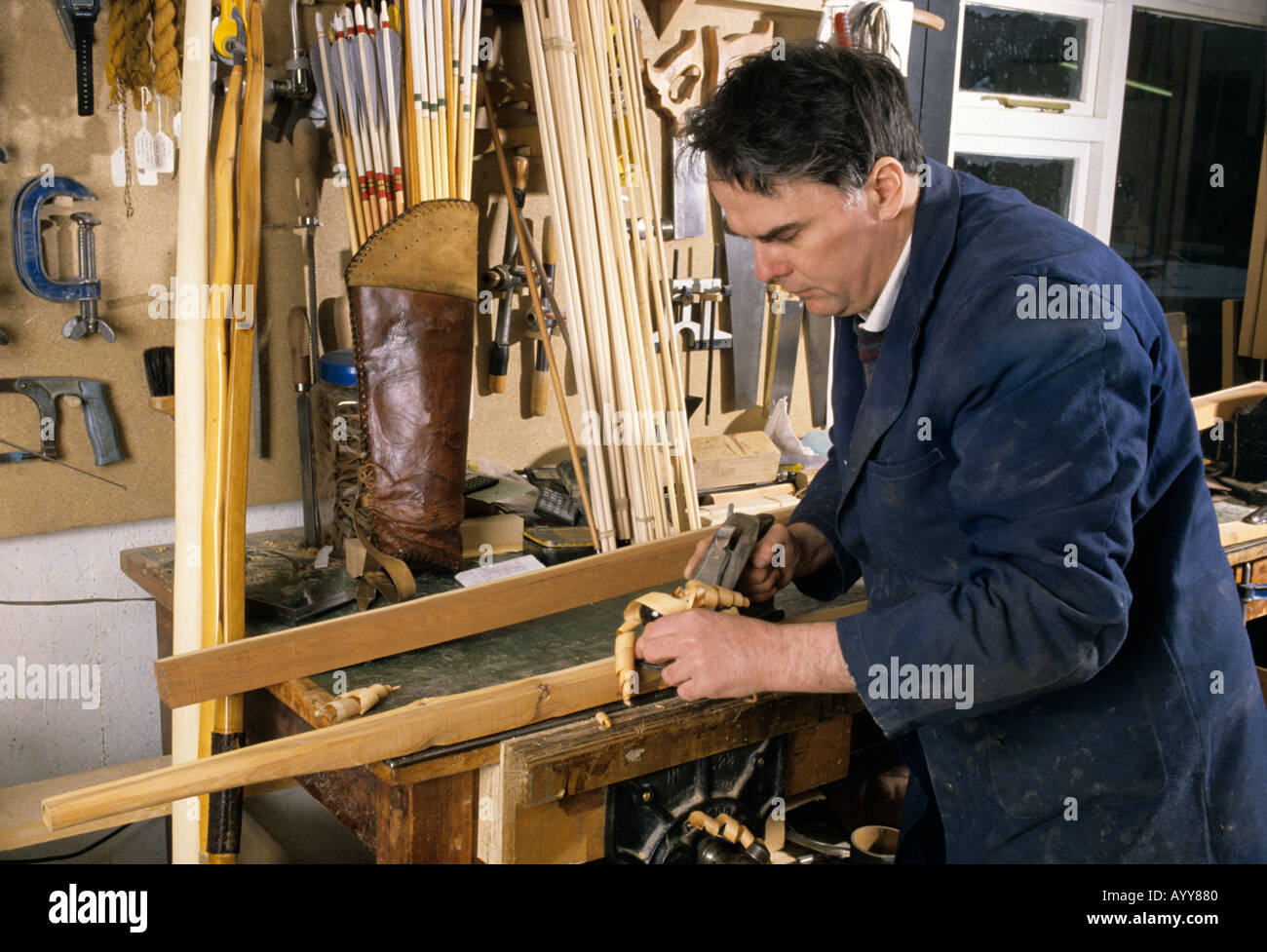 Bow and arrow maker Christopher Boyton using a plane on the surface of