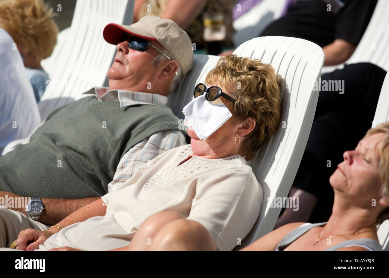 A sunbather in Blackpool seaside resort UK protects herself from the sun with a handkerchief over her face Stock Photo