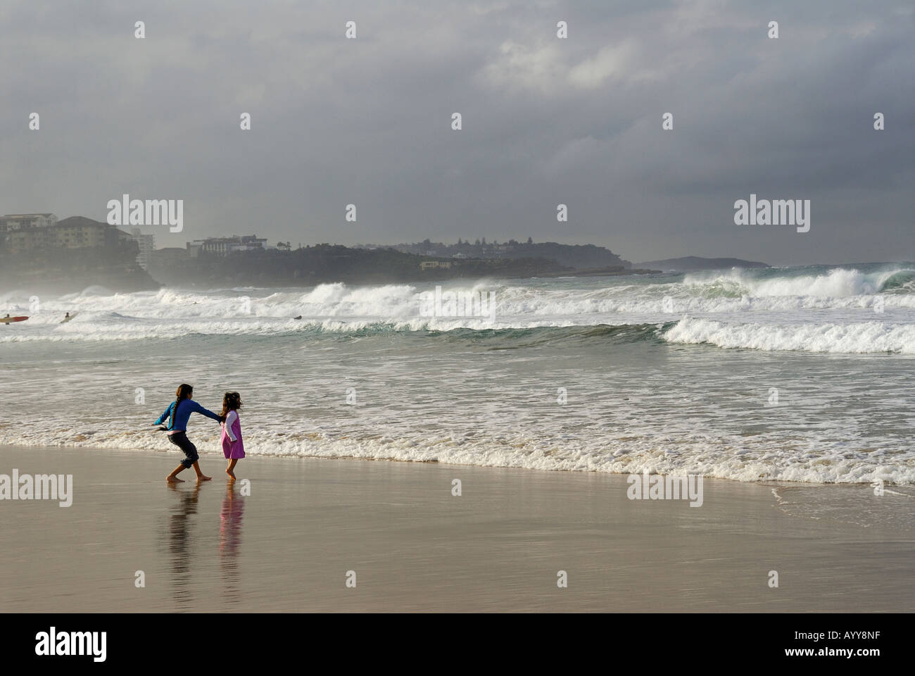 children playing in the waves on manly beach Stock Photo