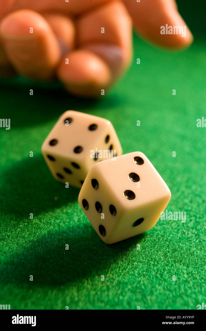 hand rolling dice onto a green baize Stock Photo Alamy