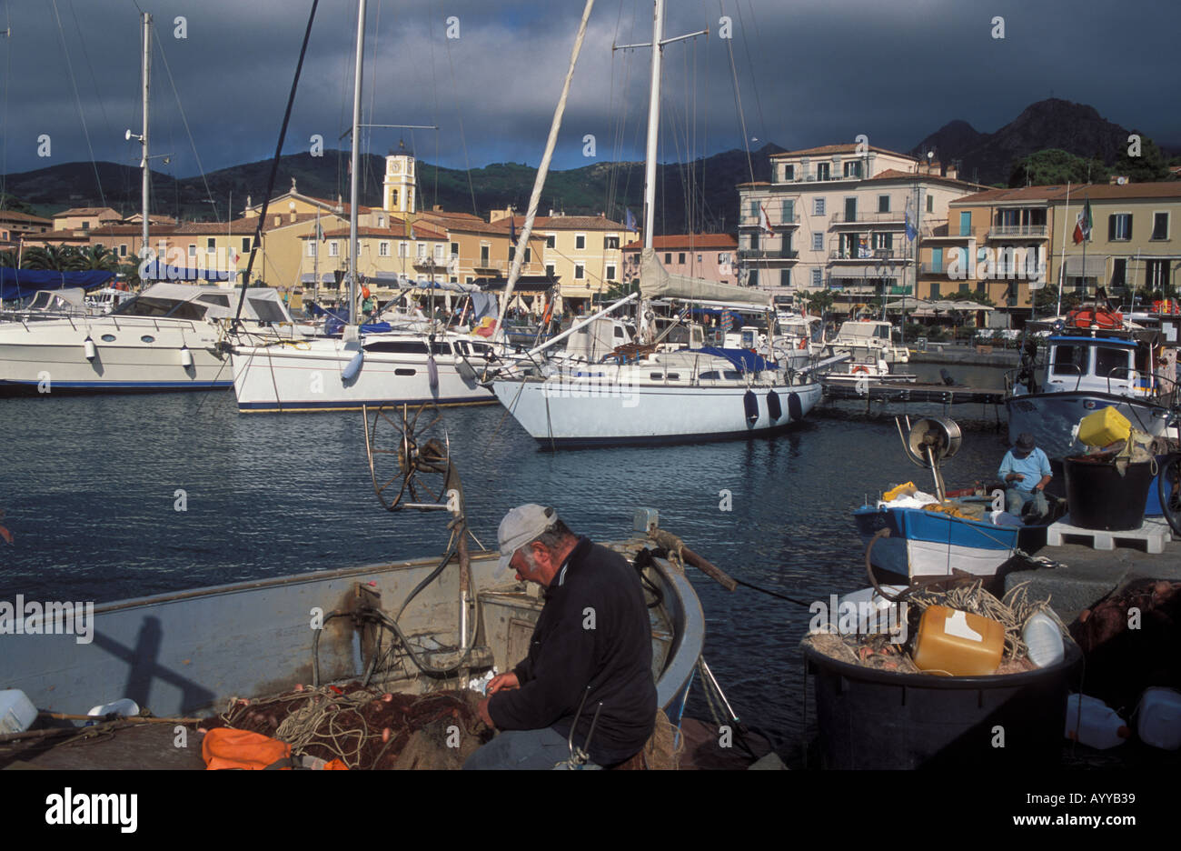Porto Azzurro harbor fishermen mending nets Island Elba Italy Stock Photo