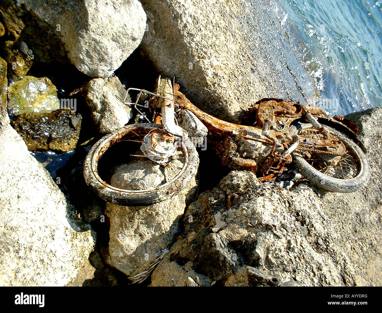 Abandoned motorbike rusting on shore in Greece Stock Photo