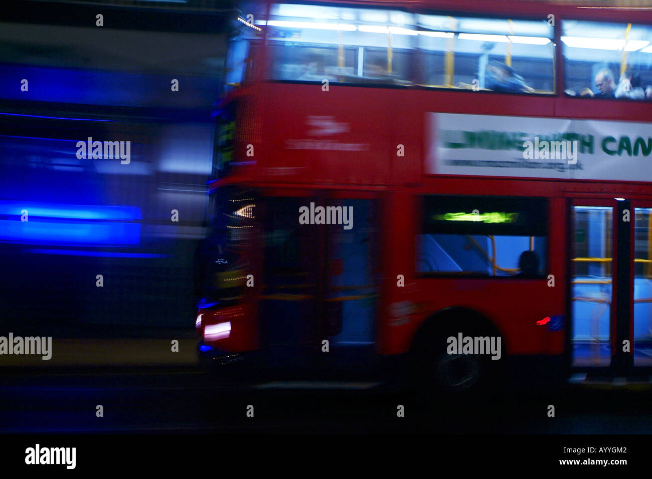 A double decker red London bus drives through the streets of London at night Stock Photo