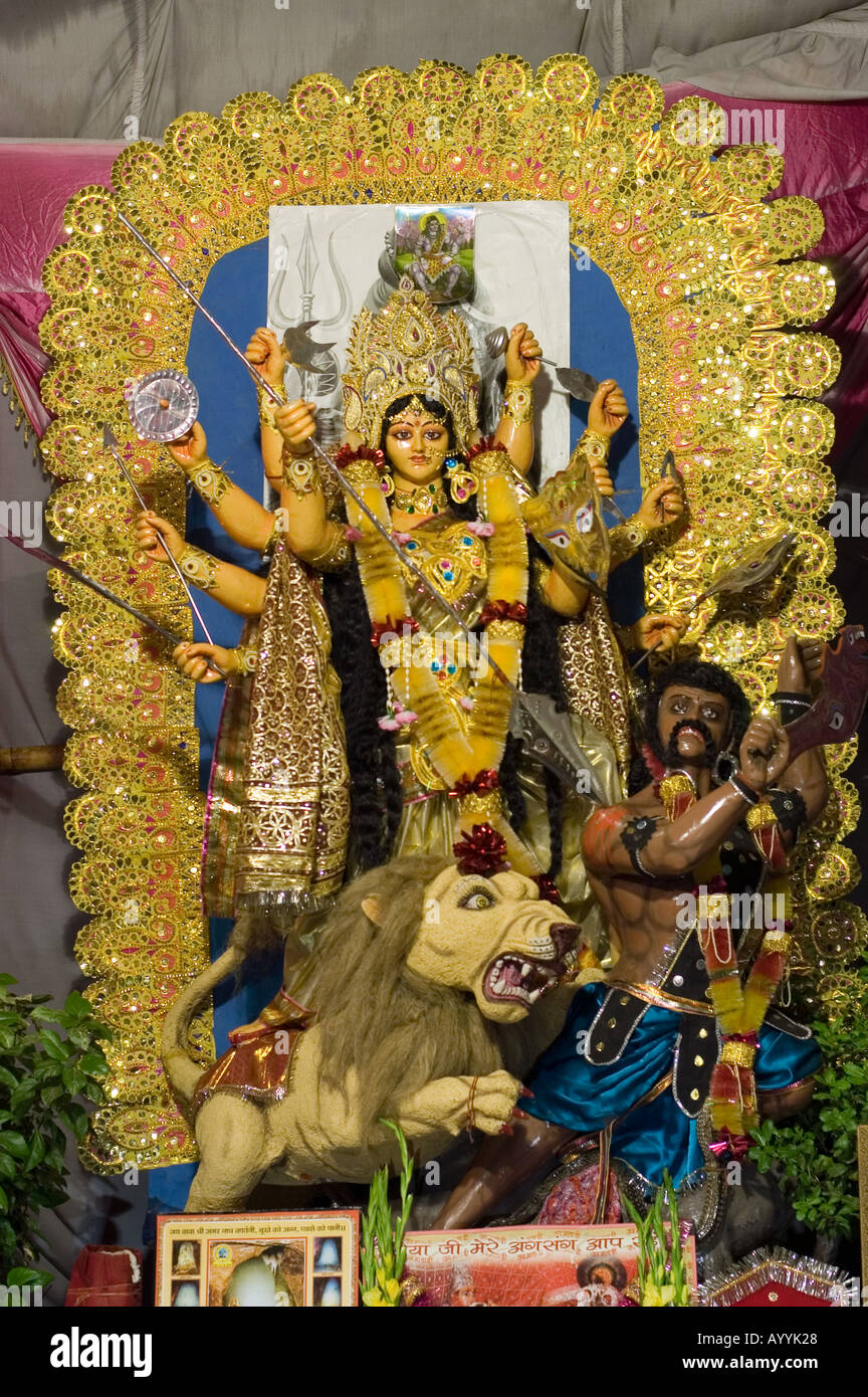 Statue of Hindu Durga goddess emanation of Kali with Lion at a festival in Old Delhi, India. Elaborate golden idol during Navratri celebrations. Stock Photo