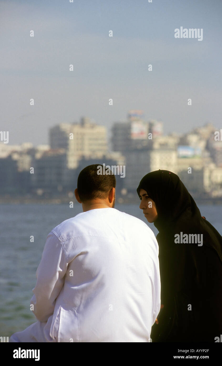 Arabic couple sitting along the Corniche Alexandria Egypt Stock Photo