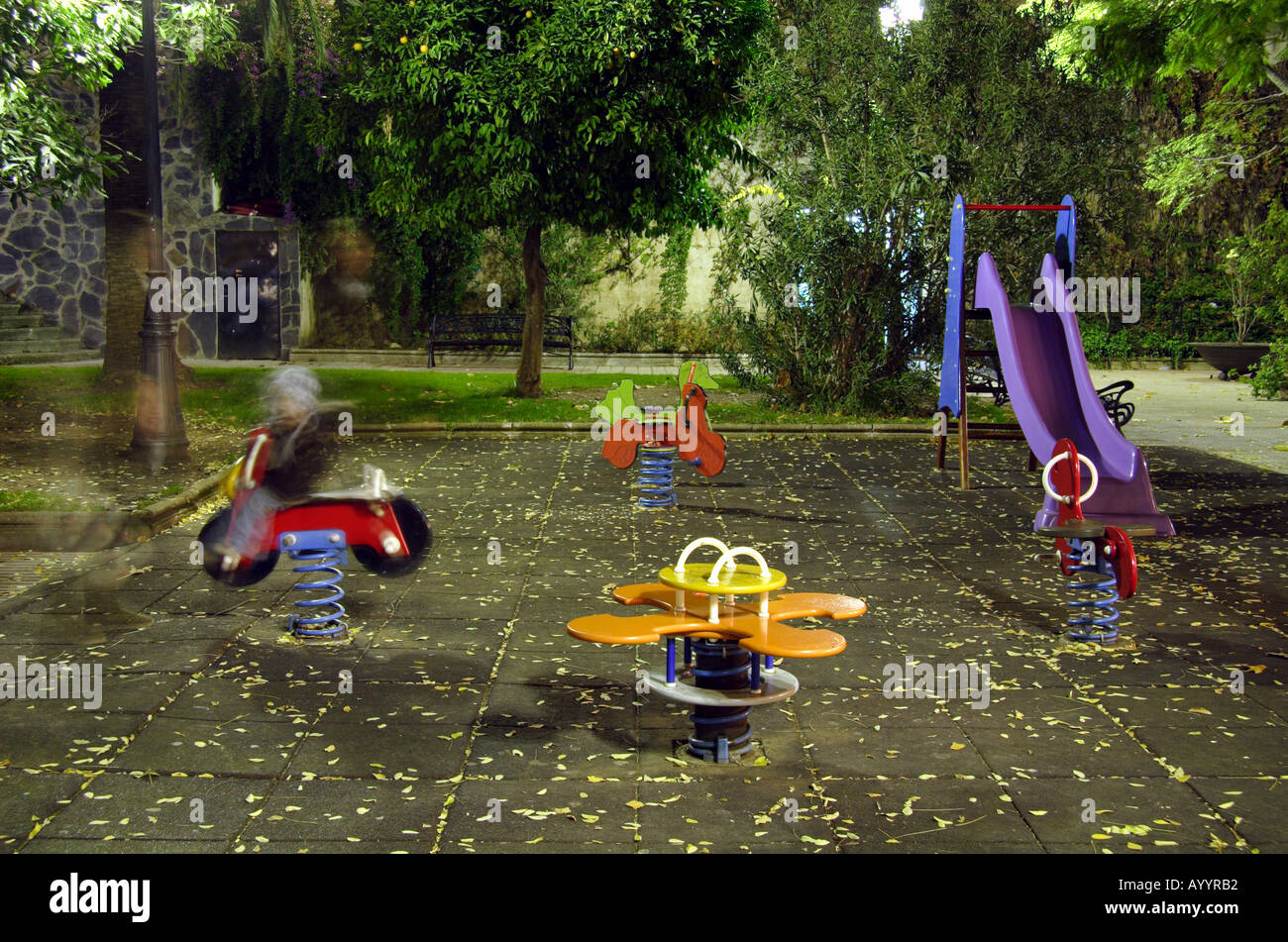 Night shot of a child playing in a playground Stock Photo