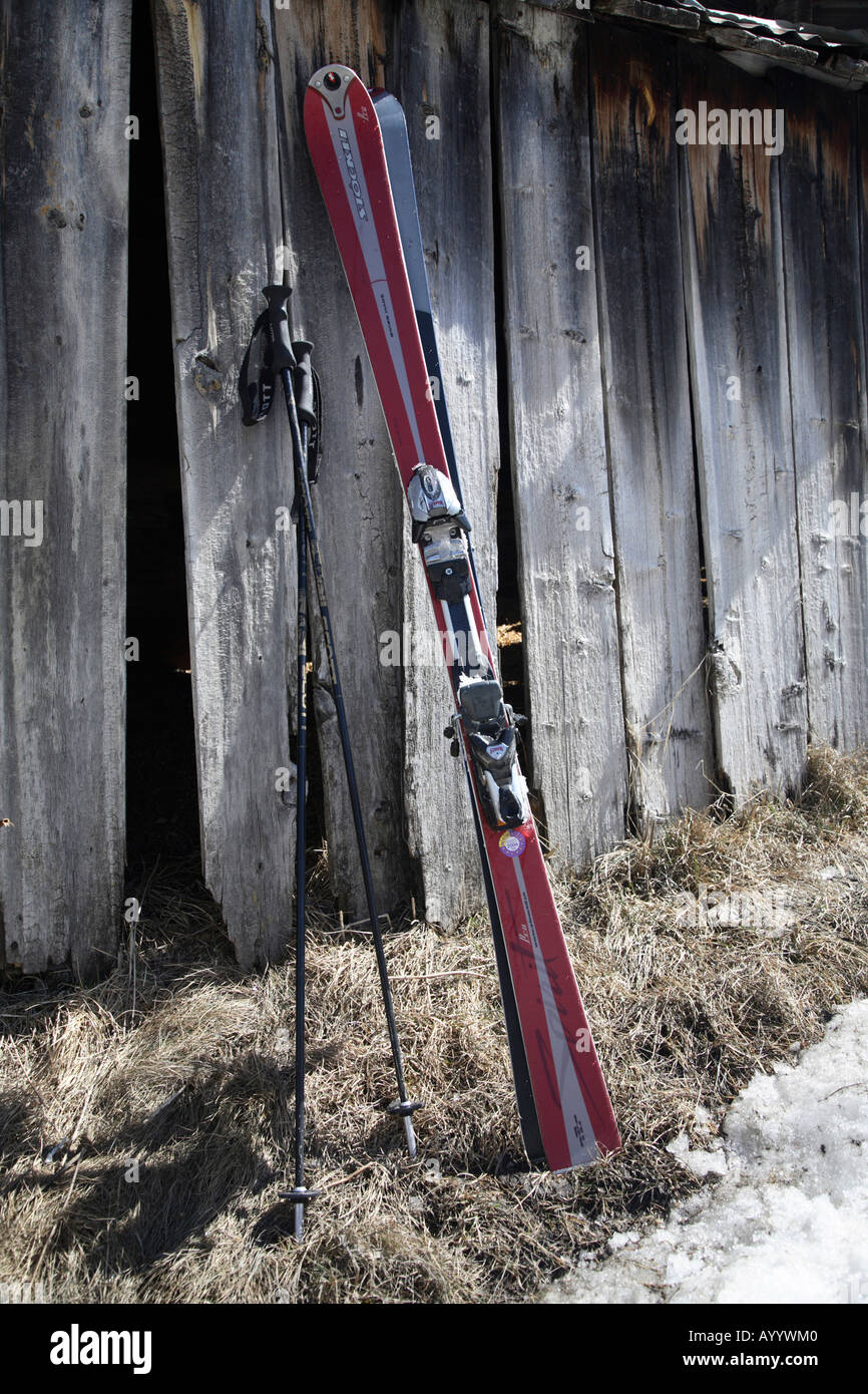 Pair of skis and poles leaning up against an old wooden hut Zermatt