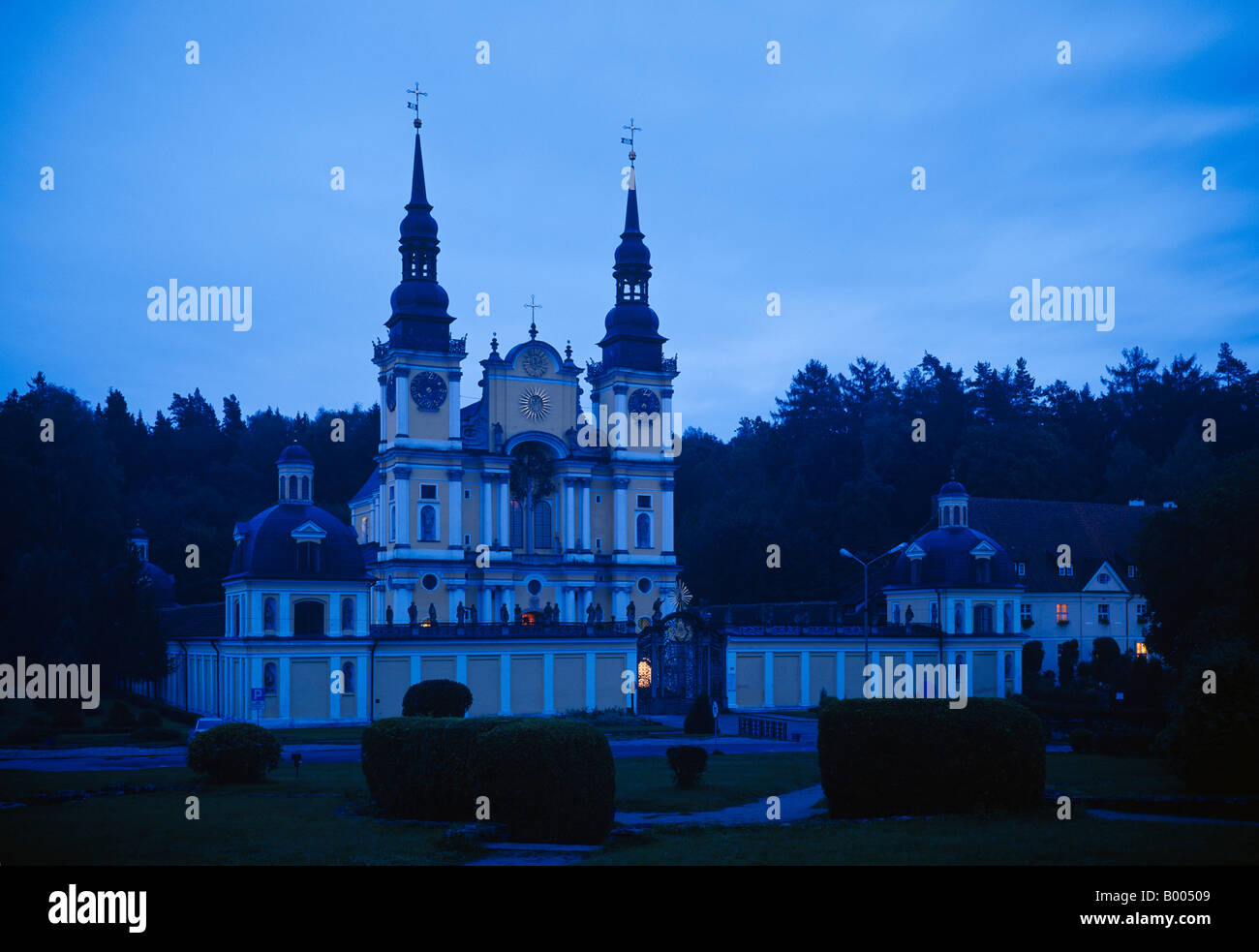 Baroque Pilgrimage Church in Swieta Lipka (Holy Lime) in masuria - blue hour. Next to the twin towers is the pilgrims shelter. Stock Photo