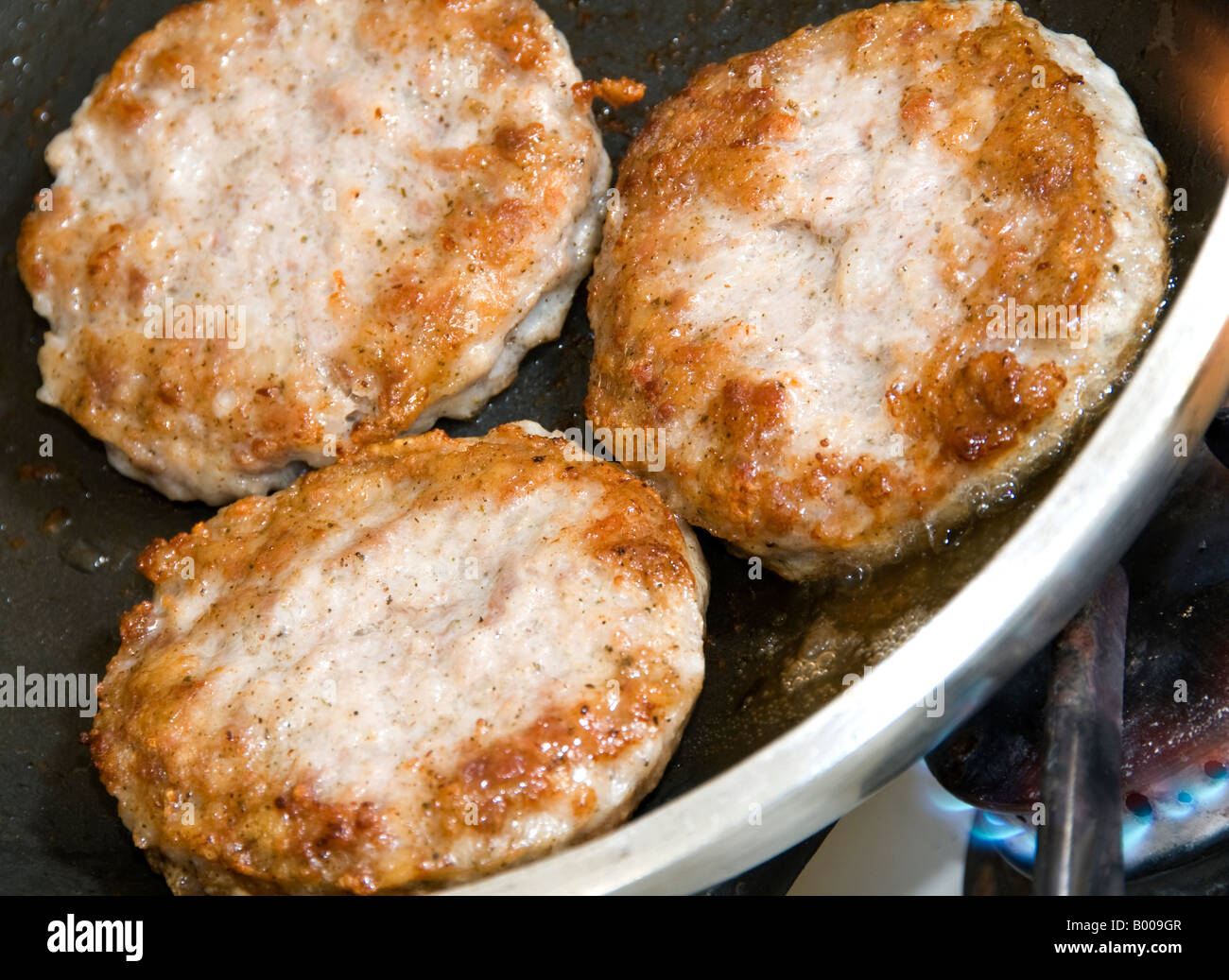pork sausage patties cooking in frying pan Stock Photo Alamy