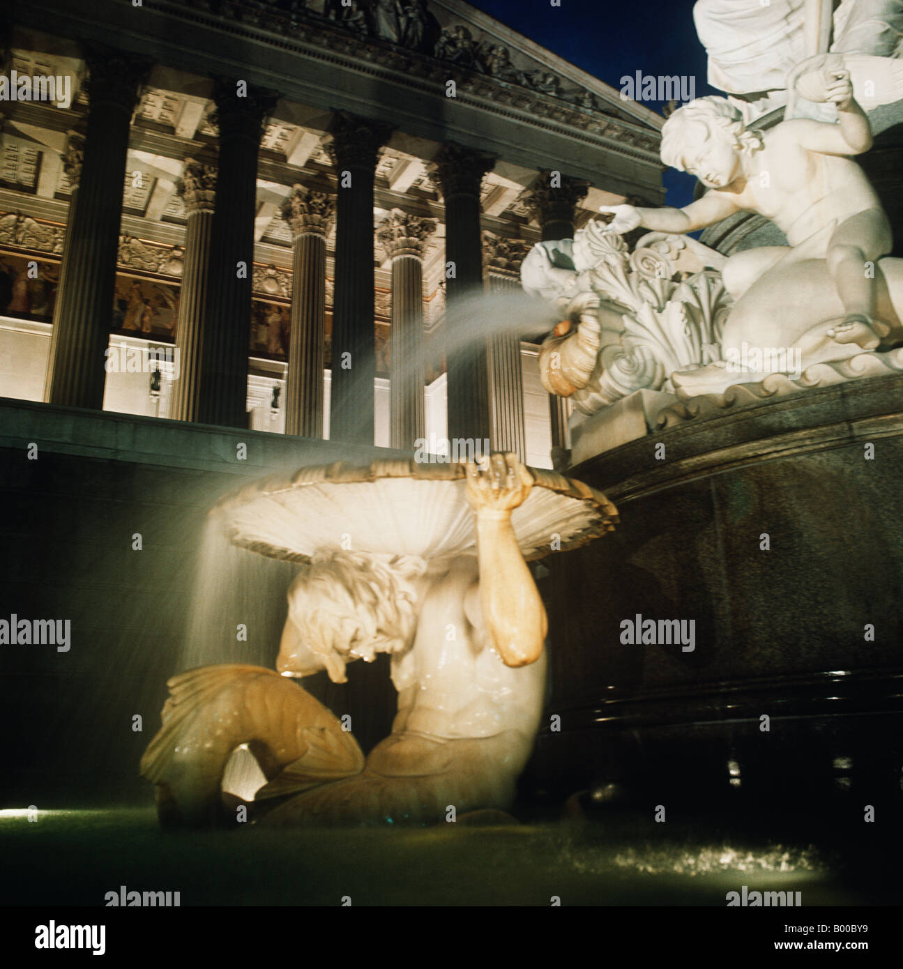 Nymphs playing with water outside the Austrian Parliament at night. Part of Pallas Athena Fountain the Greek goddess of wisdom. Stock Photo