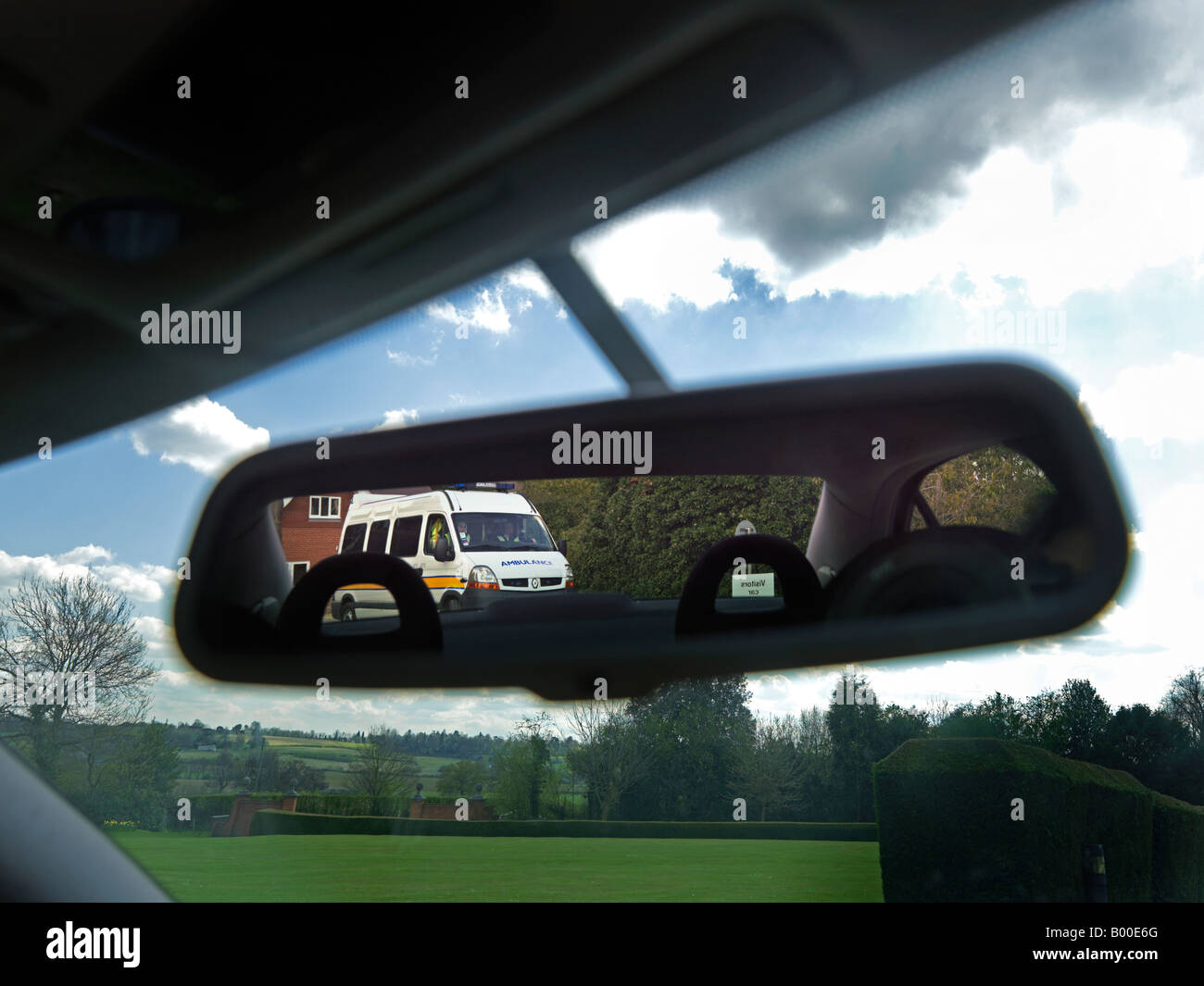 Ambulance in Rear View Mirror Showing Reversed Writing Stock Photo