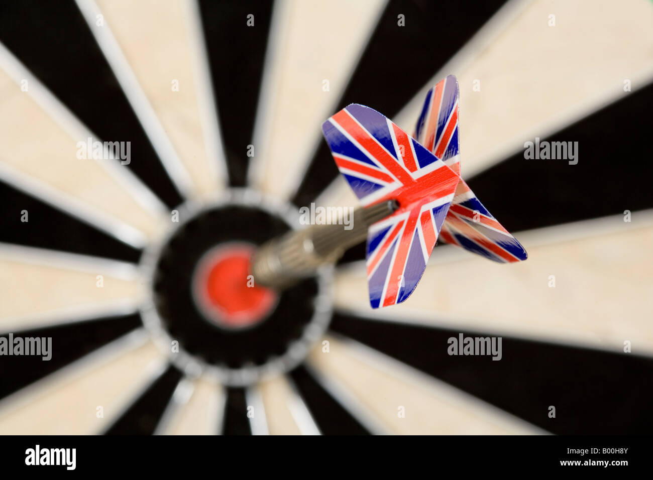 Dart arrow with Britsh national emblem sticking in the target of a dartboard Stock Photo