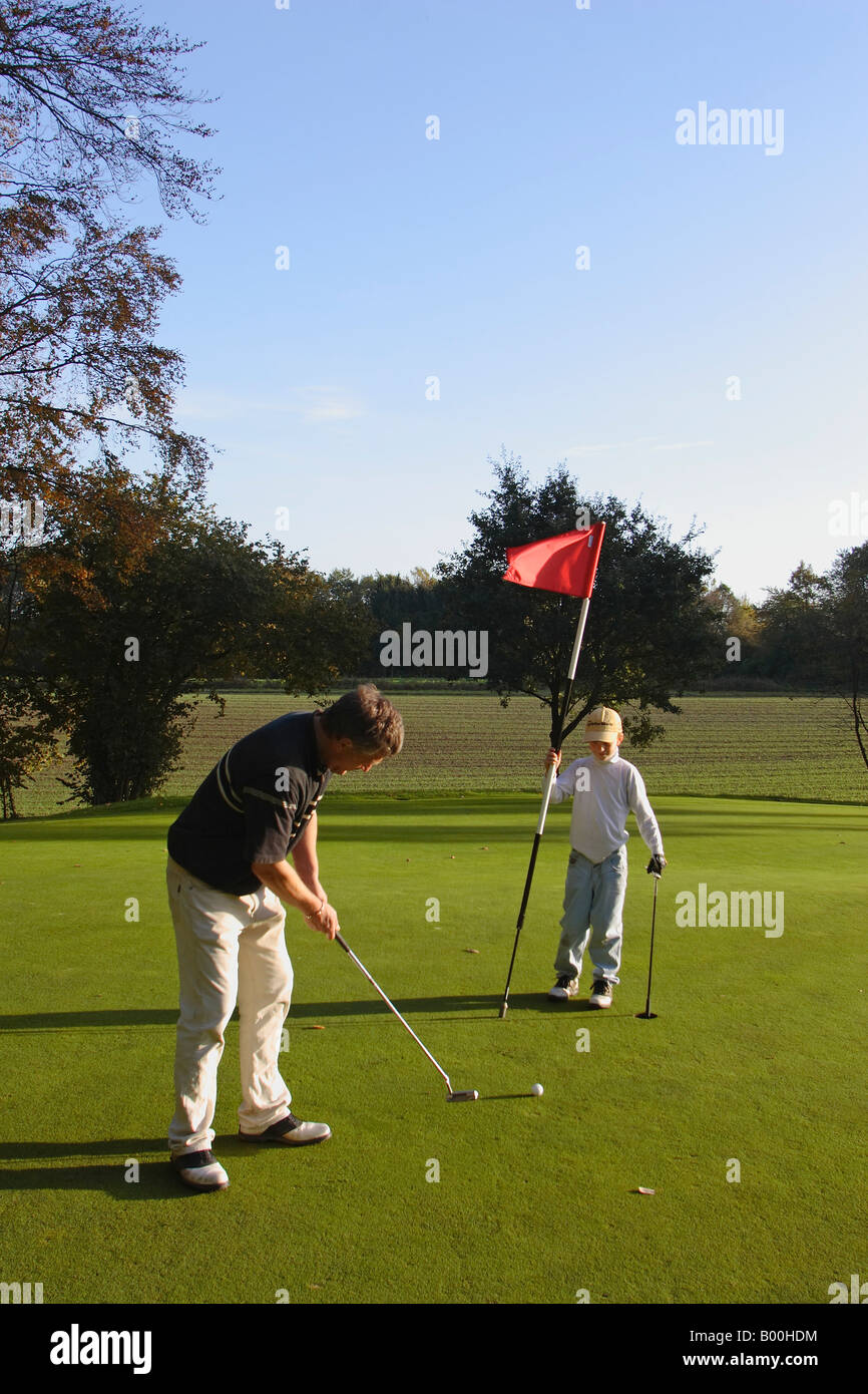 golf green putt boy with flag Stock Photo