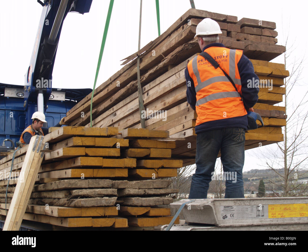 worker crane lifting large wooden decking platform Stock Photo Alamy