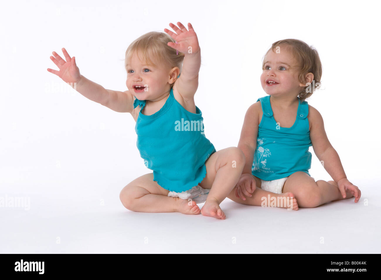 Two little girls sitting on the floor Stock Photo - Alamy