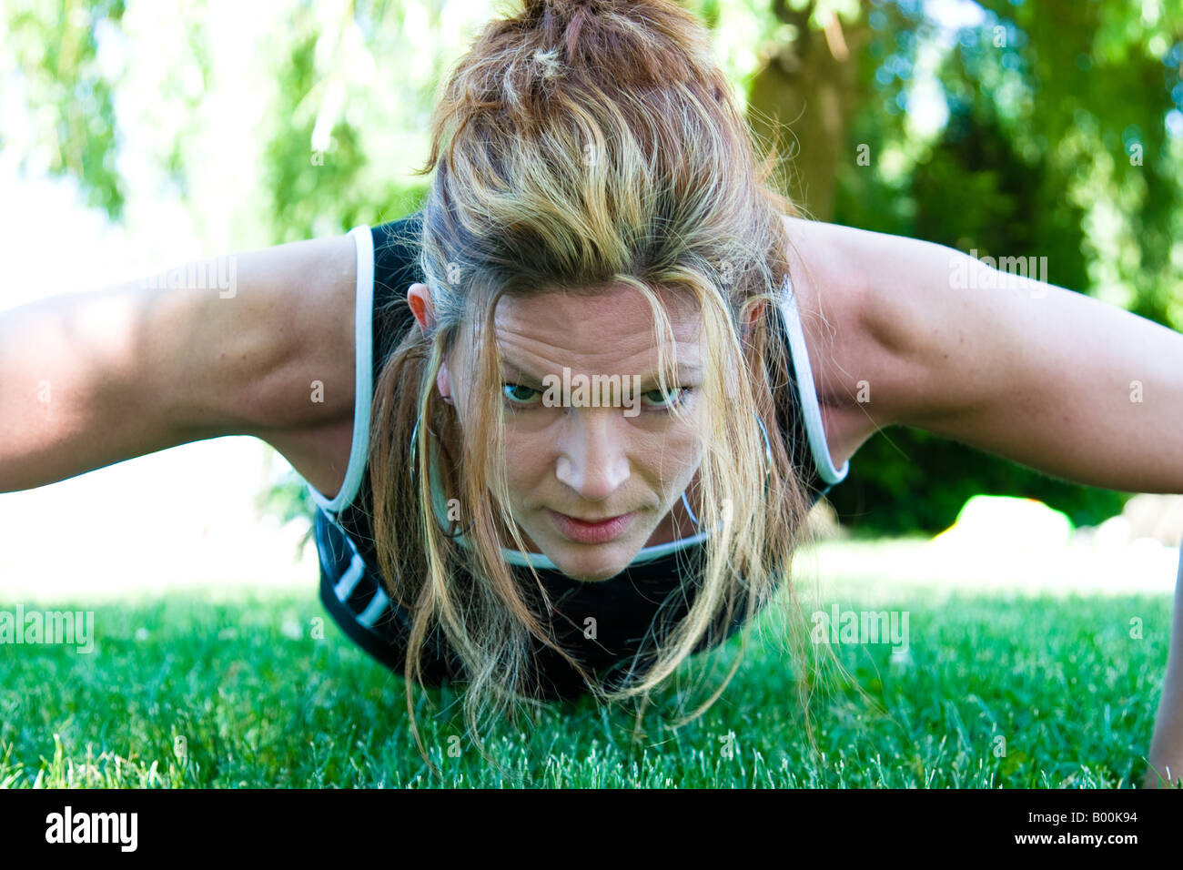 A woman doing pushups in the park Stock Photo - Alamy