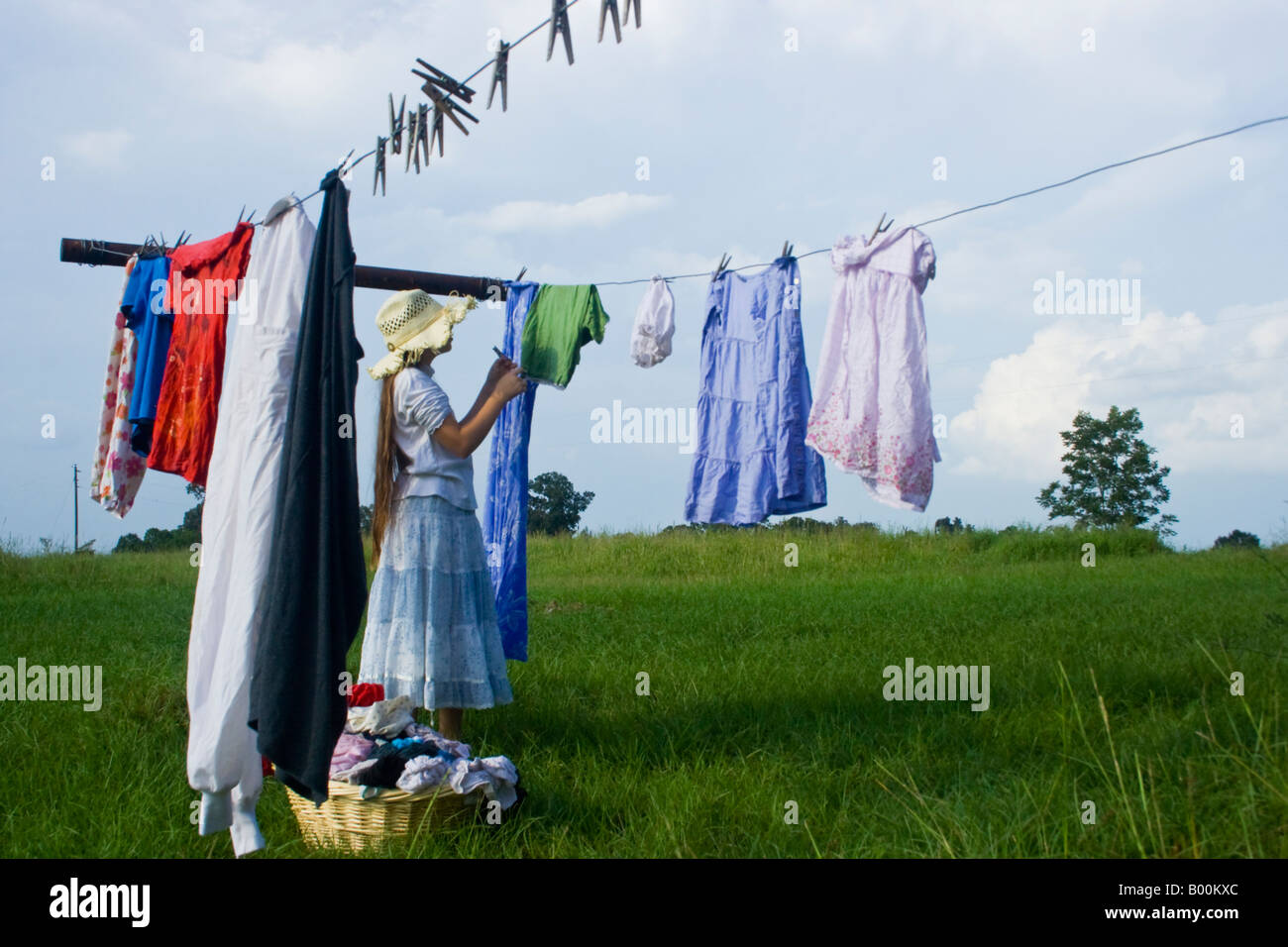 Young lady hanging clothes out on the line to dry in the summer Stock