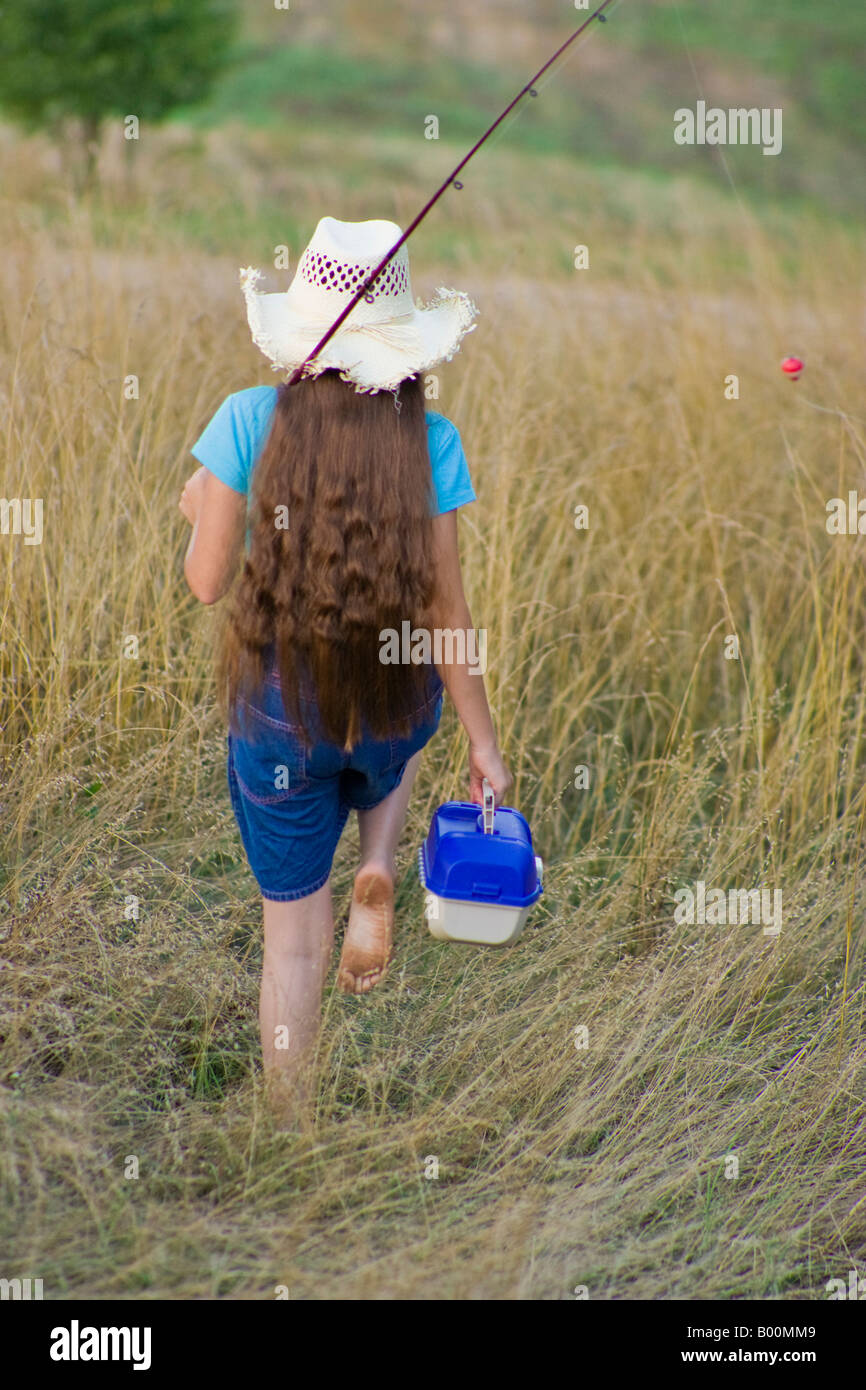 Young girl carrying a fishing pole and tackle box Stock Photo - Alamy