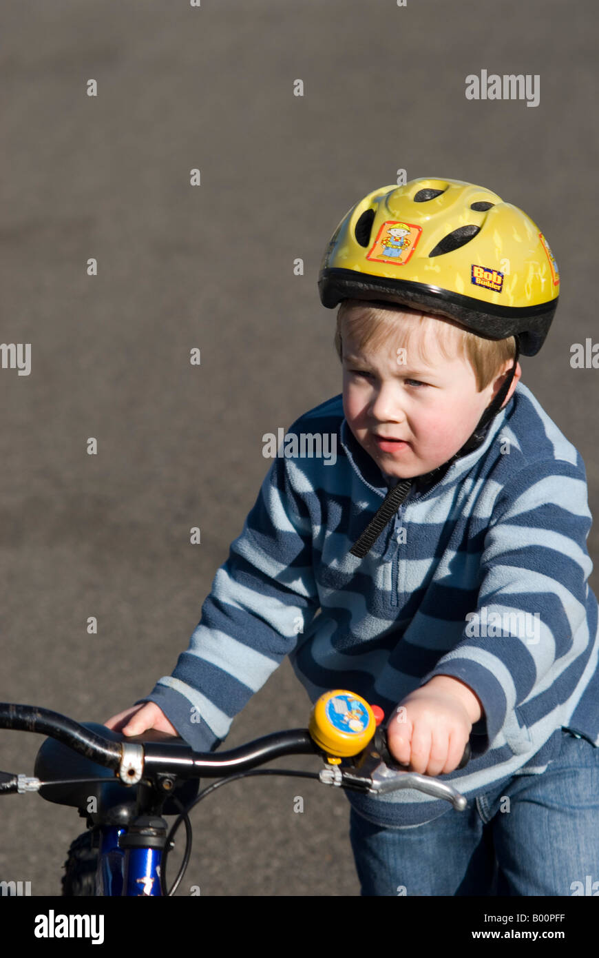 Boy riding bike with stabilisers hires stock photography and images