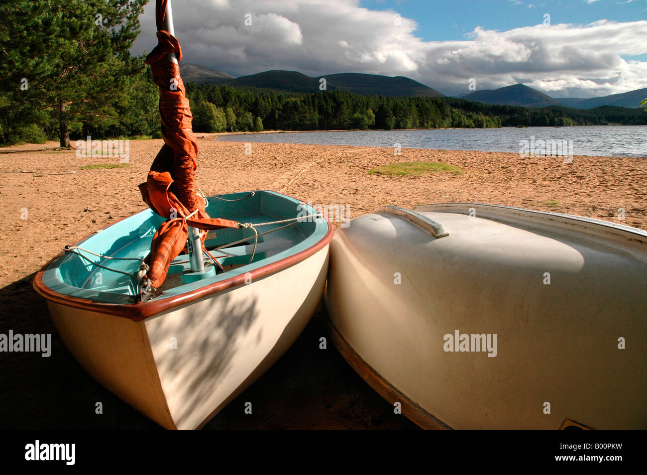 A row of dinghies lie on the sandy shores of Loch Morlich - Cairngorms, scotland, Stock Photo
