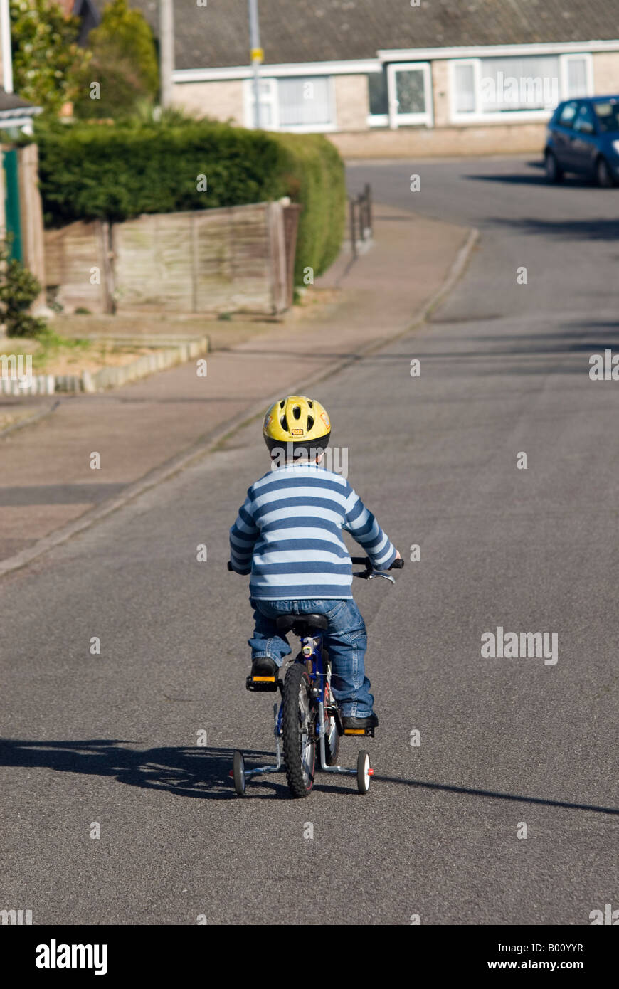 Five year old Boy On Bike in the uk wearing safety helmet Stock Photo