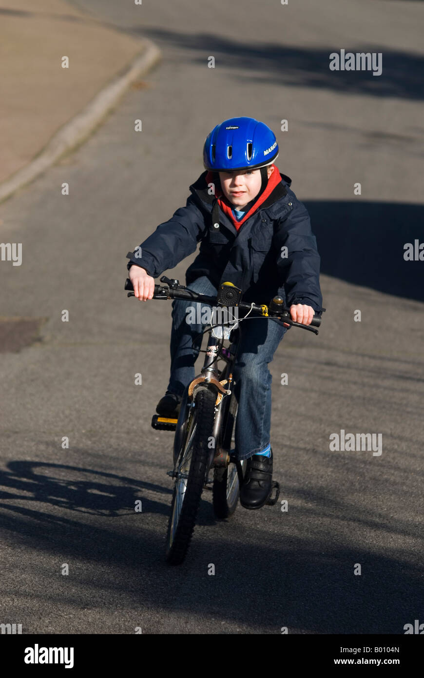 Eight year old Boy On Bike in the uk wearing safety helmet Stock Photo